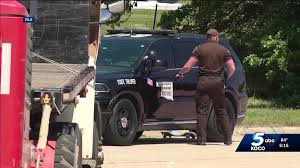 Photo credit KOCO. Highway patrolman by his car.