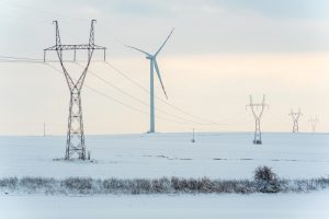 powerlines and a wind turbine in the snow